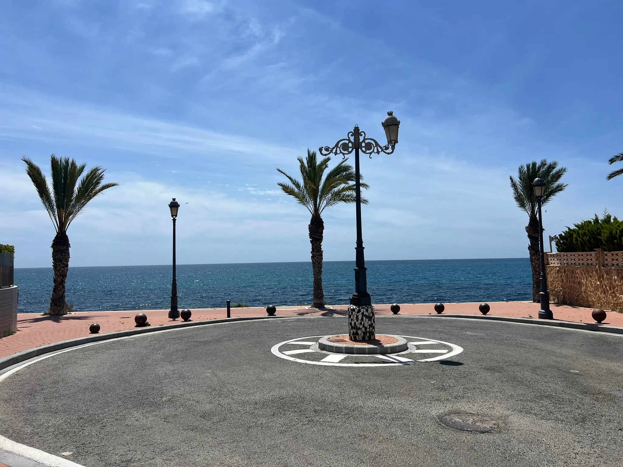 Cala Cantalar Cabo de las Huertas Alicante — decorative seafront roundabout with palm trees and Mediterranean sea view, quiet residential area
