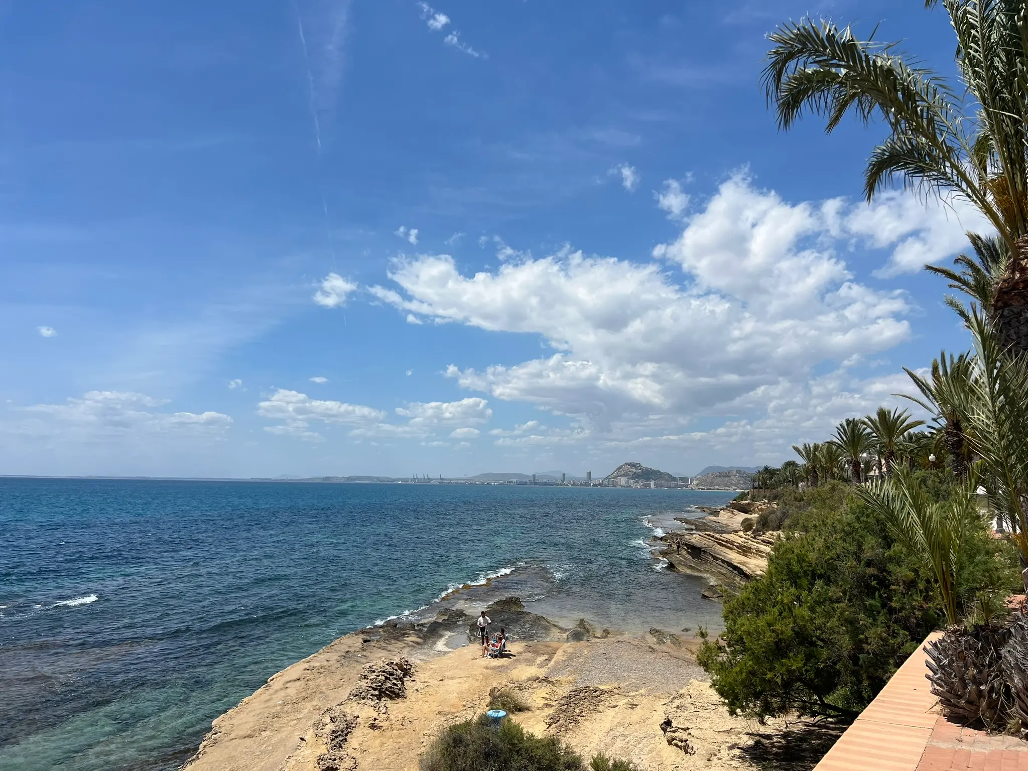 Cala Cantalar Alicante — family on rocky Cabo de las Huertas coastline with stunning panoramic views of Alicante city, Santa Barbara Castle and palm trees