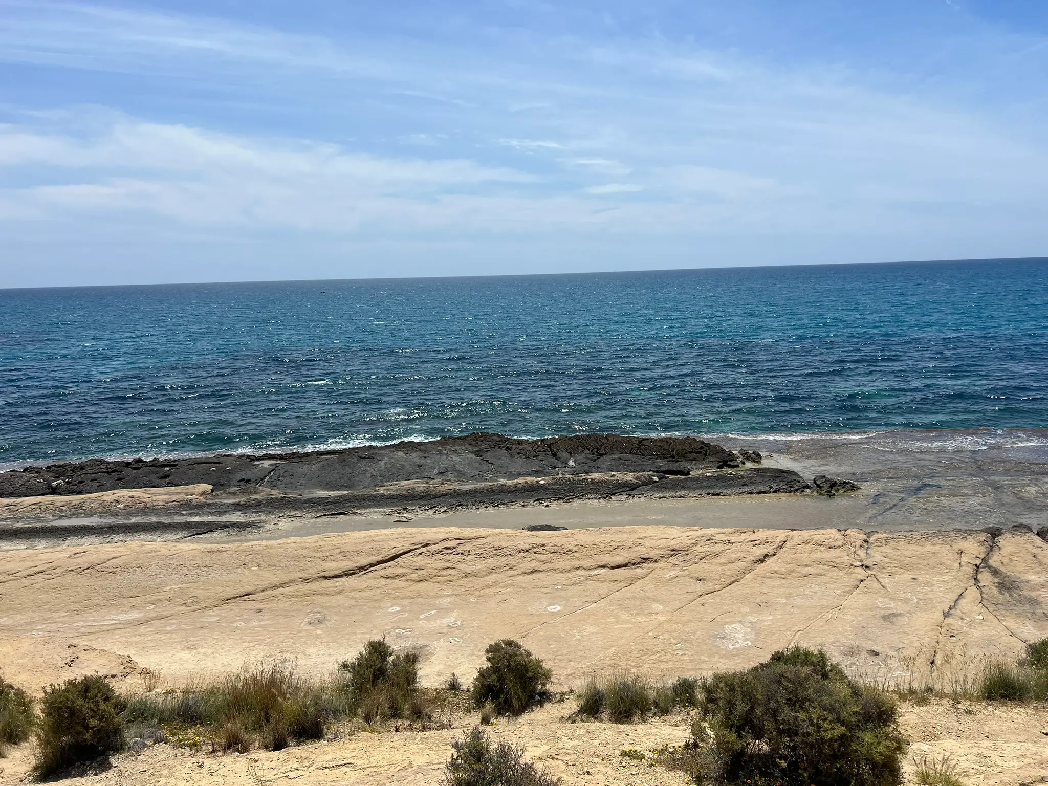 Cala Cantalar Alicante — flat natural rock platforms at Cabo de las Huertas with deep blue Mediterranean sea, ideal sunbathing and snorkelling spot