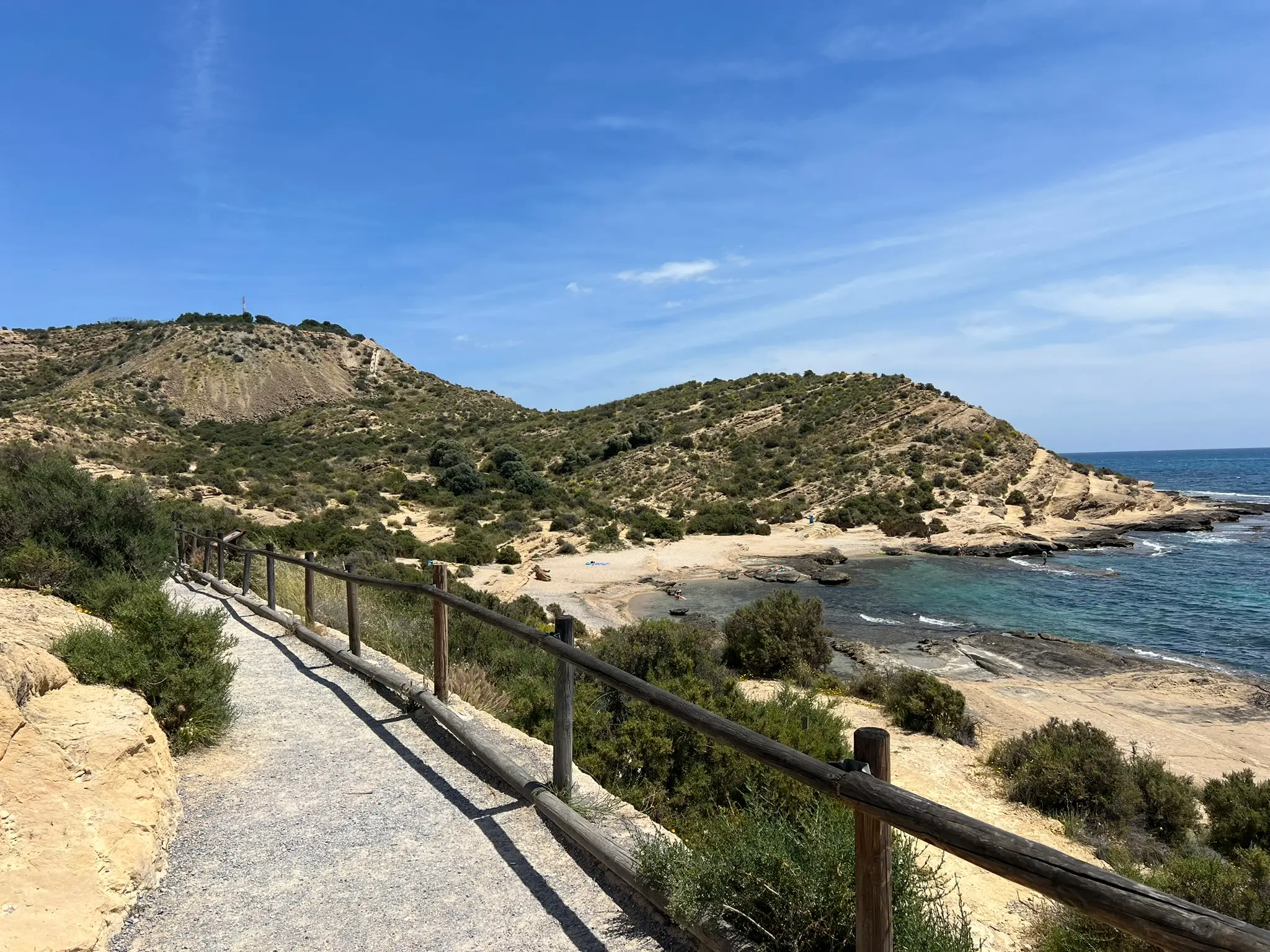Cala Cantalar Alicante — wooden railing hiking path leading down to the secluded rocky cove at Cabo de las Huertas with turquoise Mediterranean water