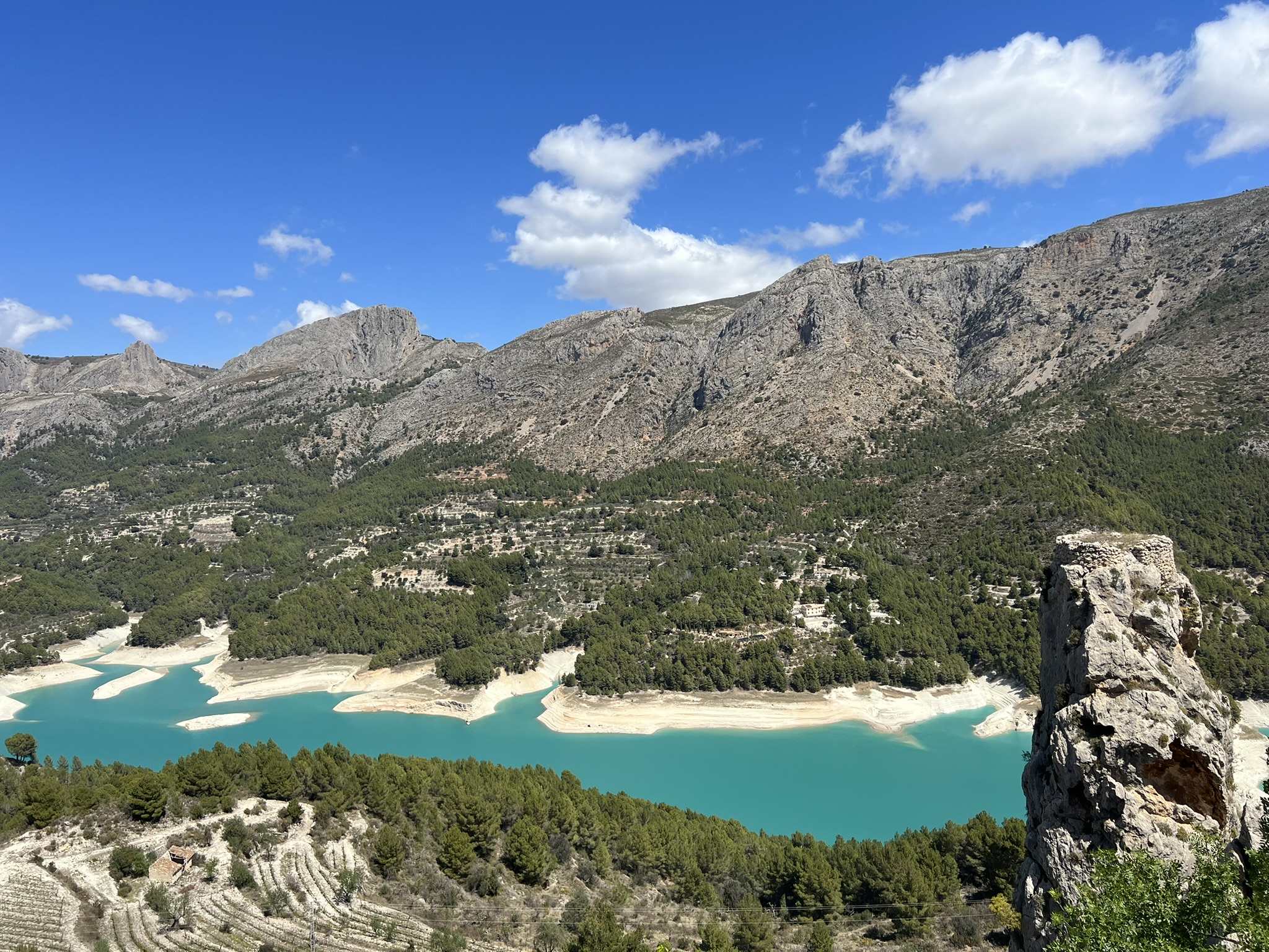 Guadalest und das zerfallene Castillo de San José auf der Felsspitze über dem türkisfarbenen Stausee Embalse de Guadalest