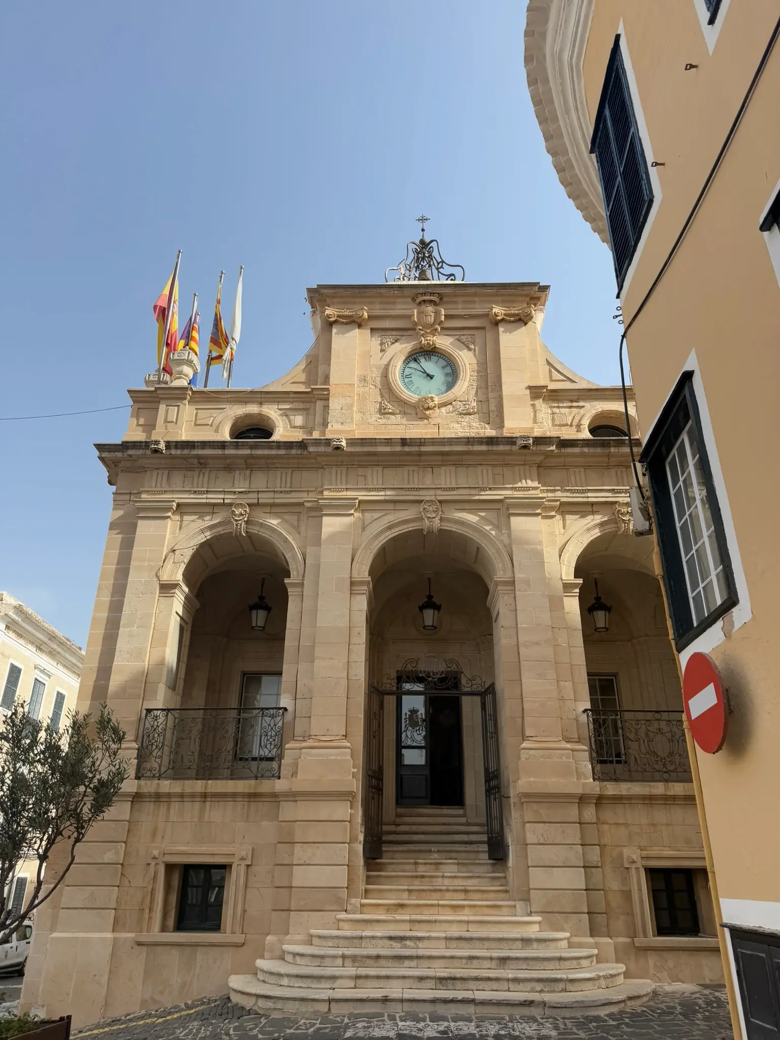 De klokkentoren en zuilengevel van een historisch gebouw in Mahón, Menorca