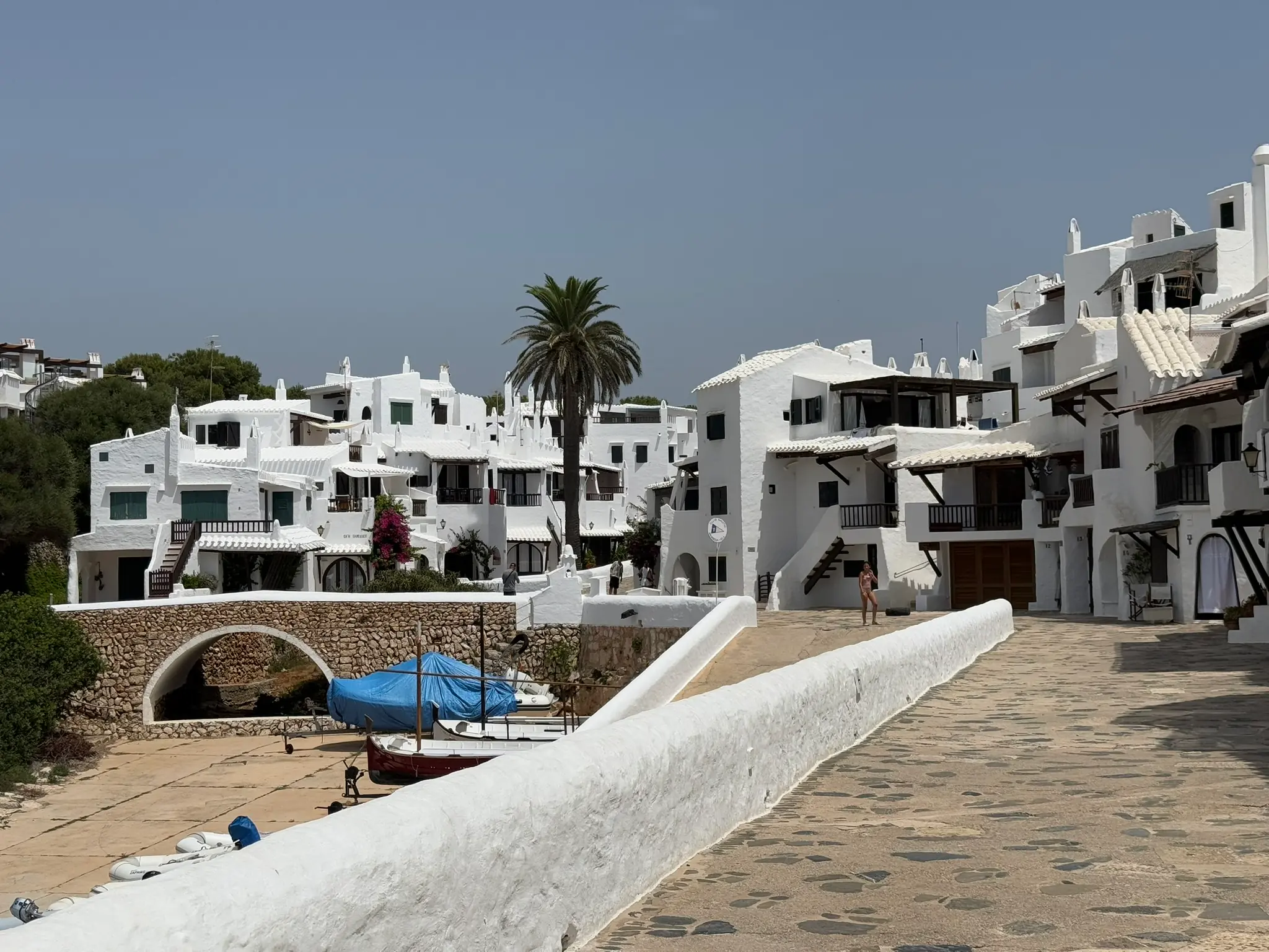 Een witgekalkt vissersdorp aan de kust van Menorca, boten op de stenen kade
