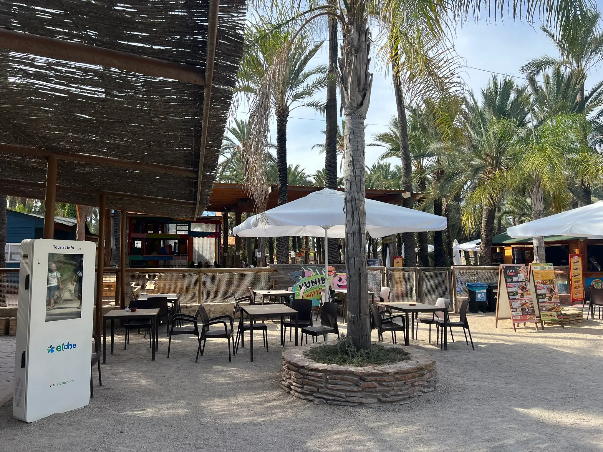 Caféterrasse mit Sonnenschirmen unter Palmen im Rio Safari Elche