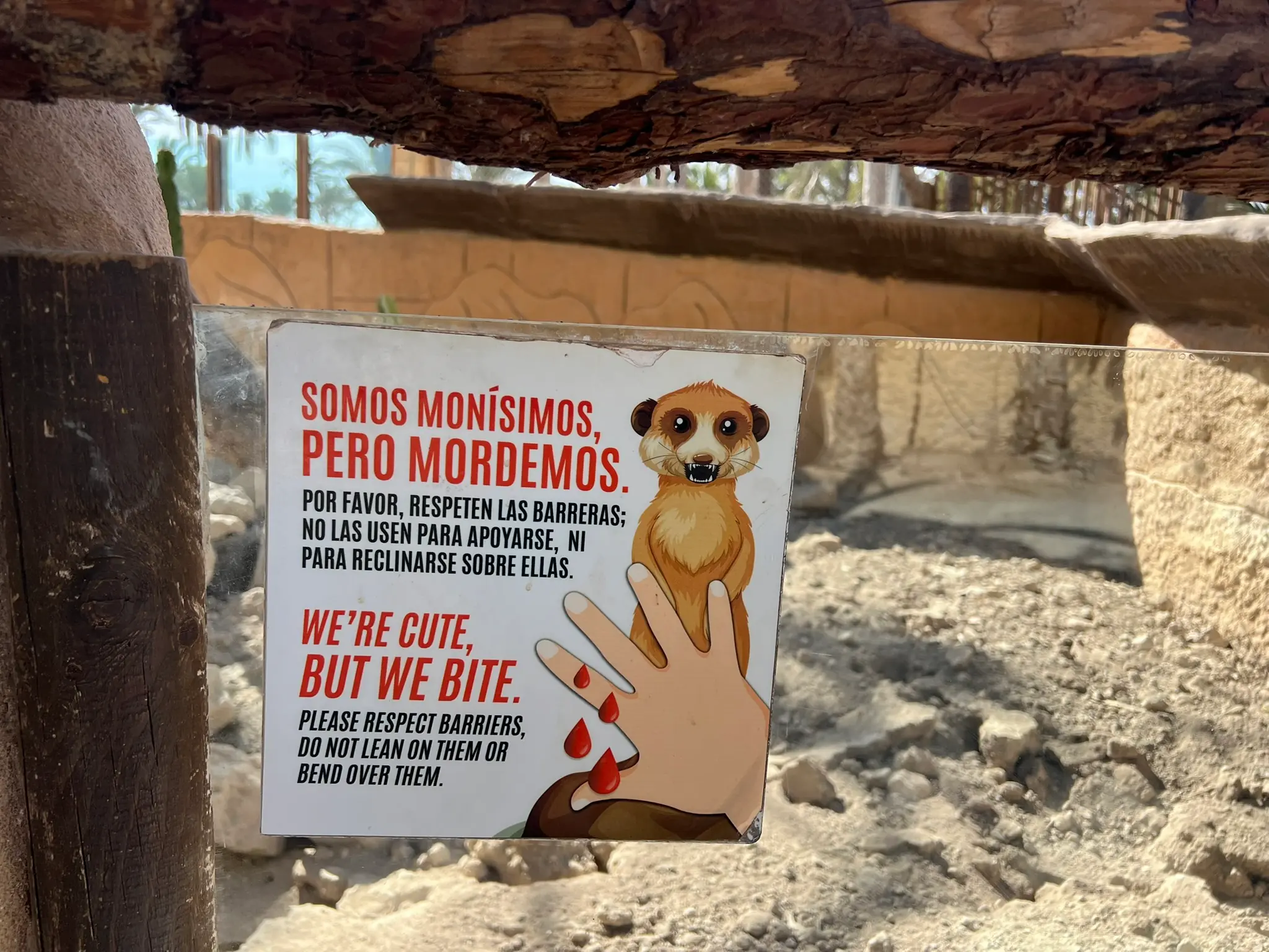 Schild am Erdmännchengehege mit der Aufschrift "Somos monísimos, pero mordemos" im Rio Safari Elche